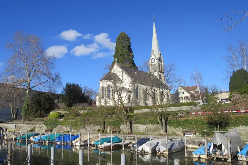 Umzug in Erlenbach: reformierte Kirche am Seeufer mit Hafen