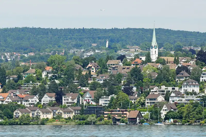 Umzug in Zollikon: Blick vom Zürichsee auf das Dorf mit Kirche